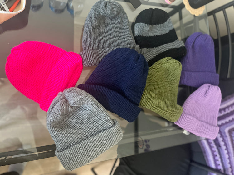 Black and gray striped beanie and white beanie with folded cuffs