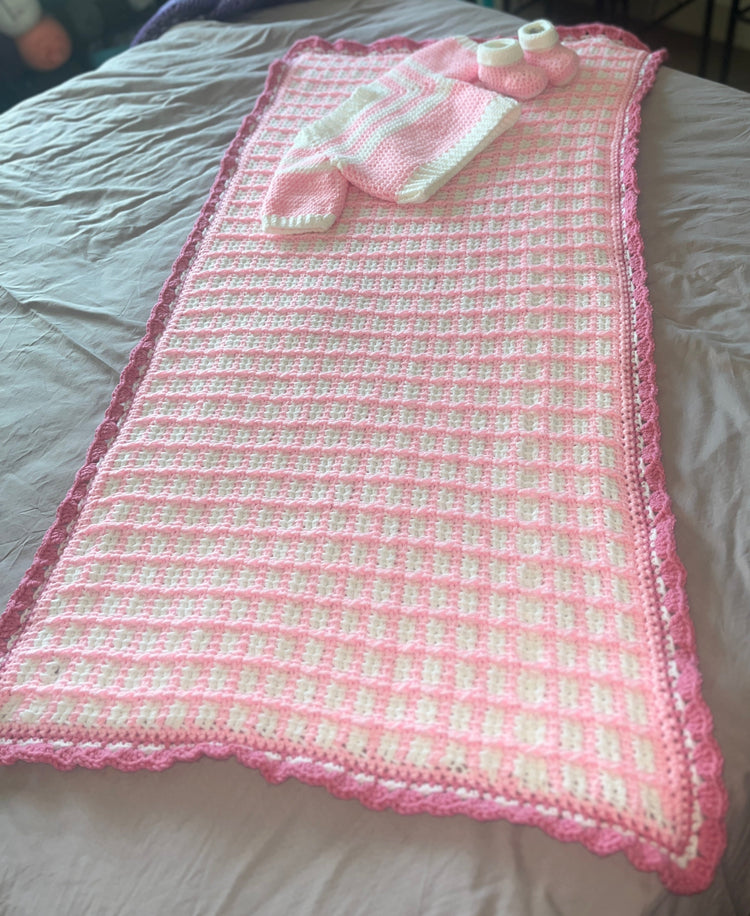 Full-length view of pink-and-white Tunisian crochet baby blanket set