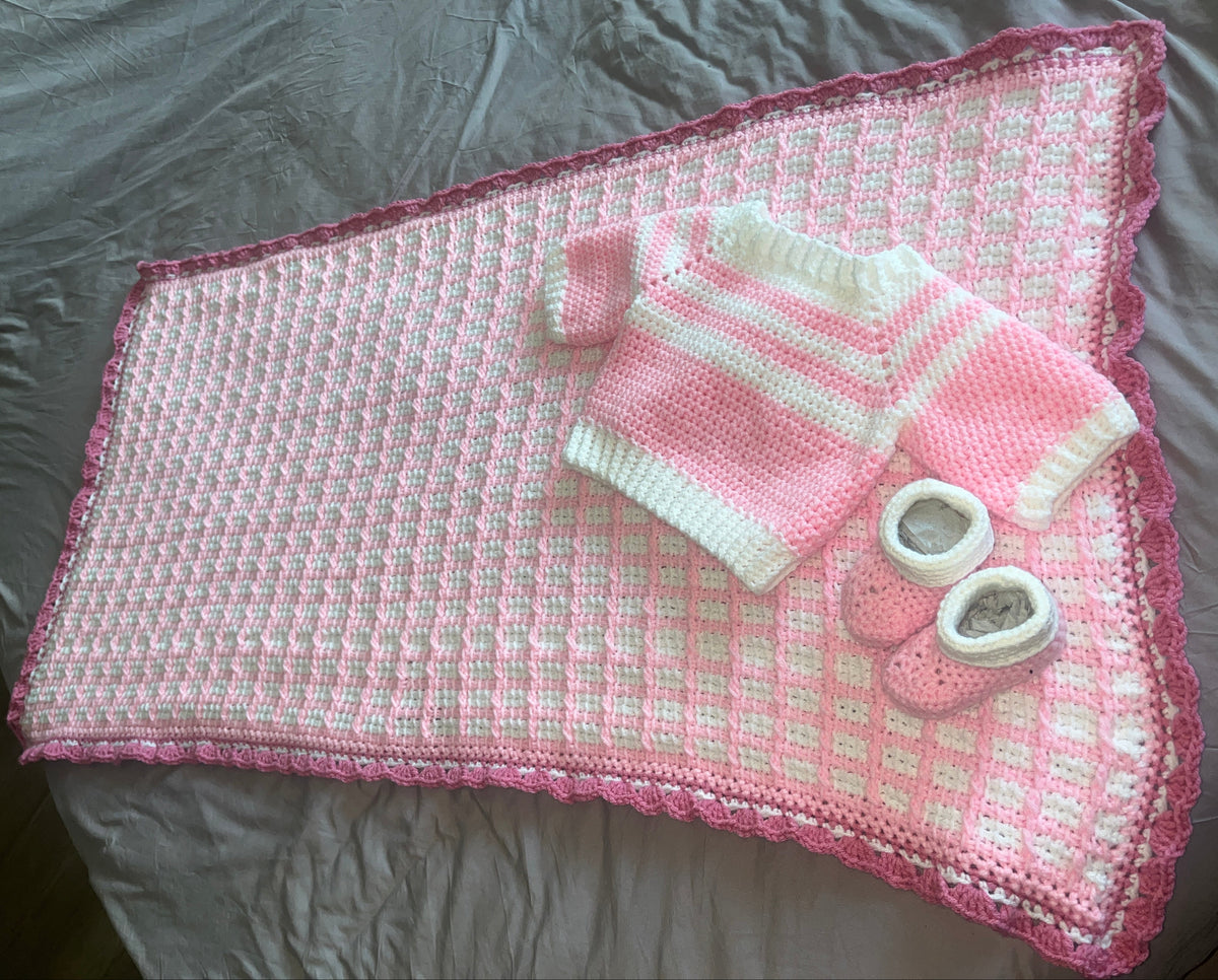 Tunisian crochet blanket with scalloped pink border, matching sweater and booties
