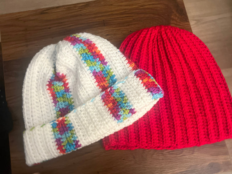 Crochet beanies in orange, royal blue, green, and orange and green stripes