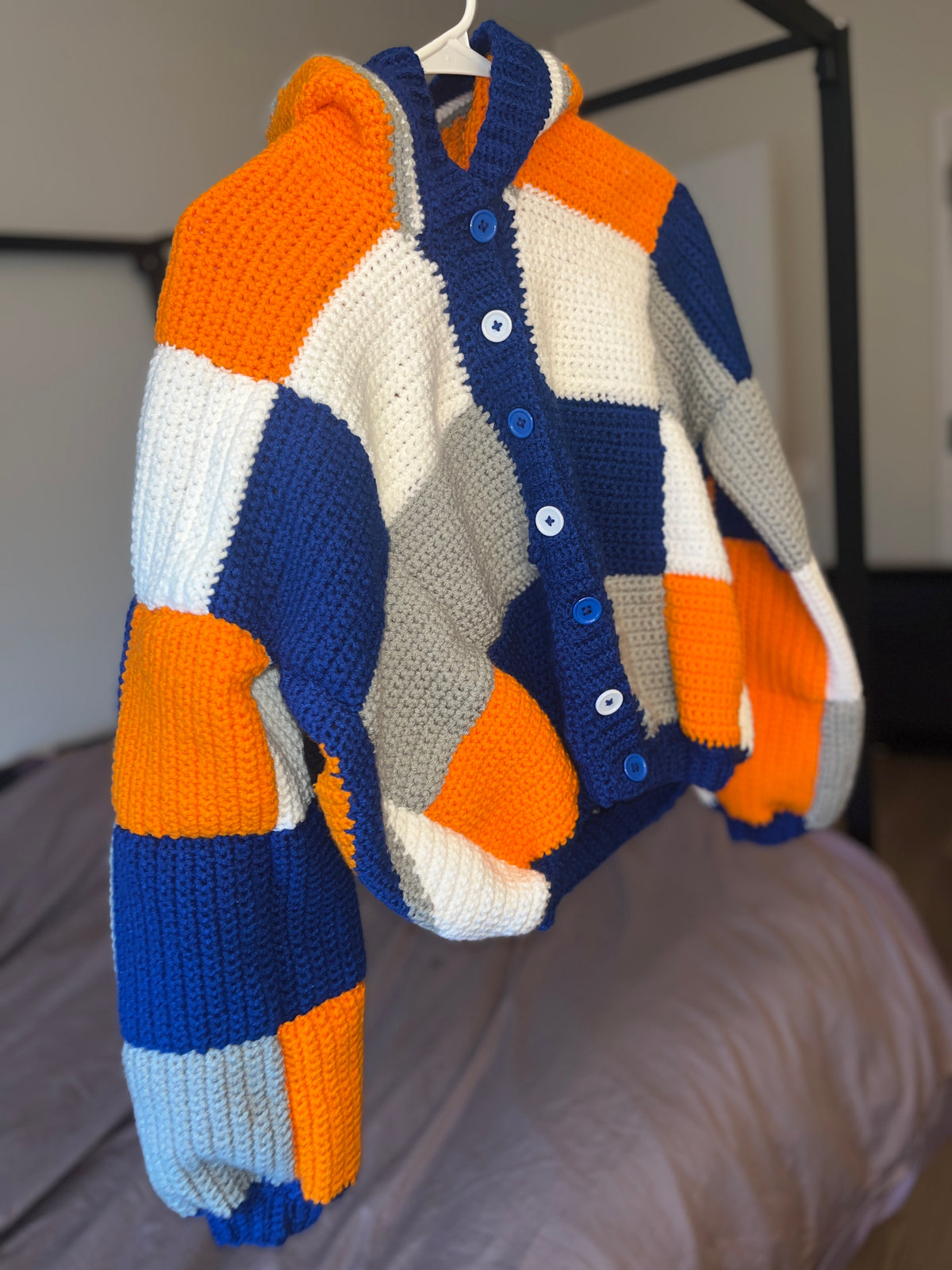 Orange and blue patchwork crochet hooded cardigan, front view